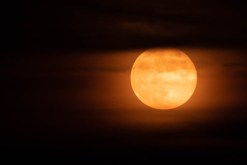 orange full moon with whispy clouds