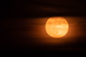 orange full moon with whispy clouds