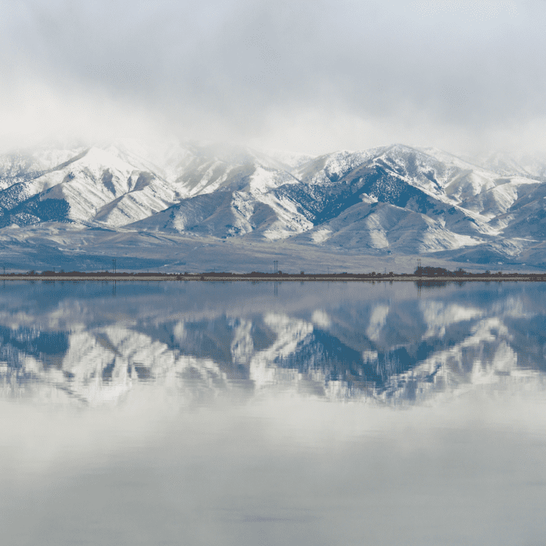 snow capped mountains reflected on lake